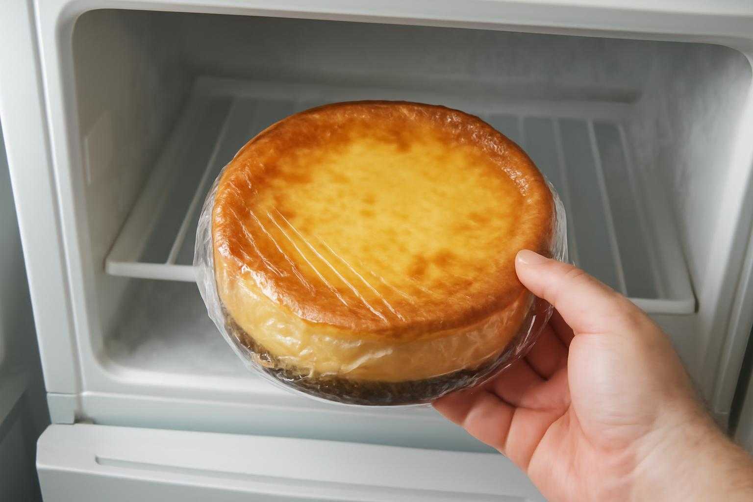 ラップに包まれたベイクドチーズケーキを冷凍庫に入れる様子